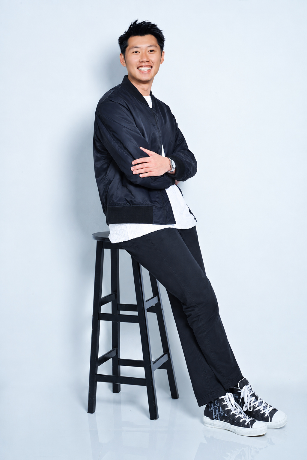 Justin Ngai seated on a tall stool