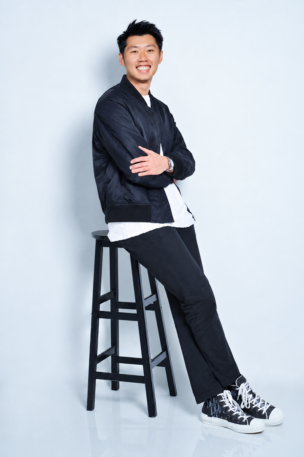 Justin Ngai seated on a tall stool